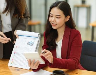 A young asian woman presents data in a meeting