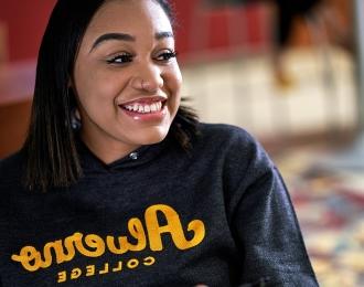 A student wearing an vnsr威尼斯城官网登入 sweatshirt smiles